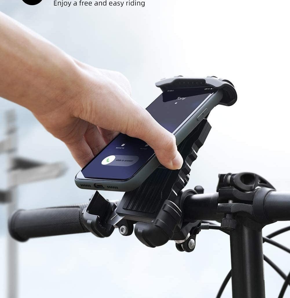 a person lifting their phone out of the bike mount with one hand