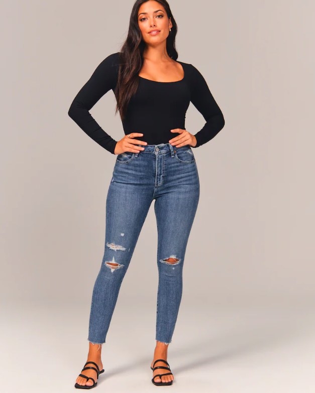 Model wearing jeans, black top and black sandals