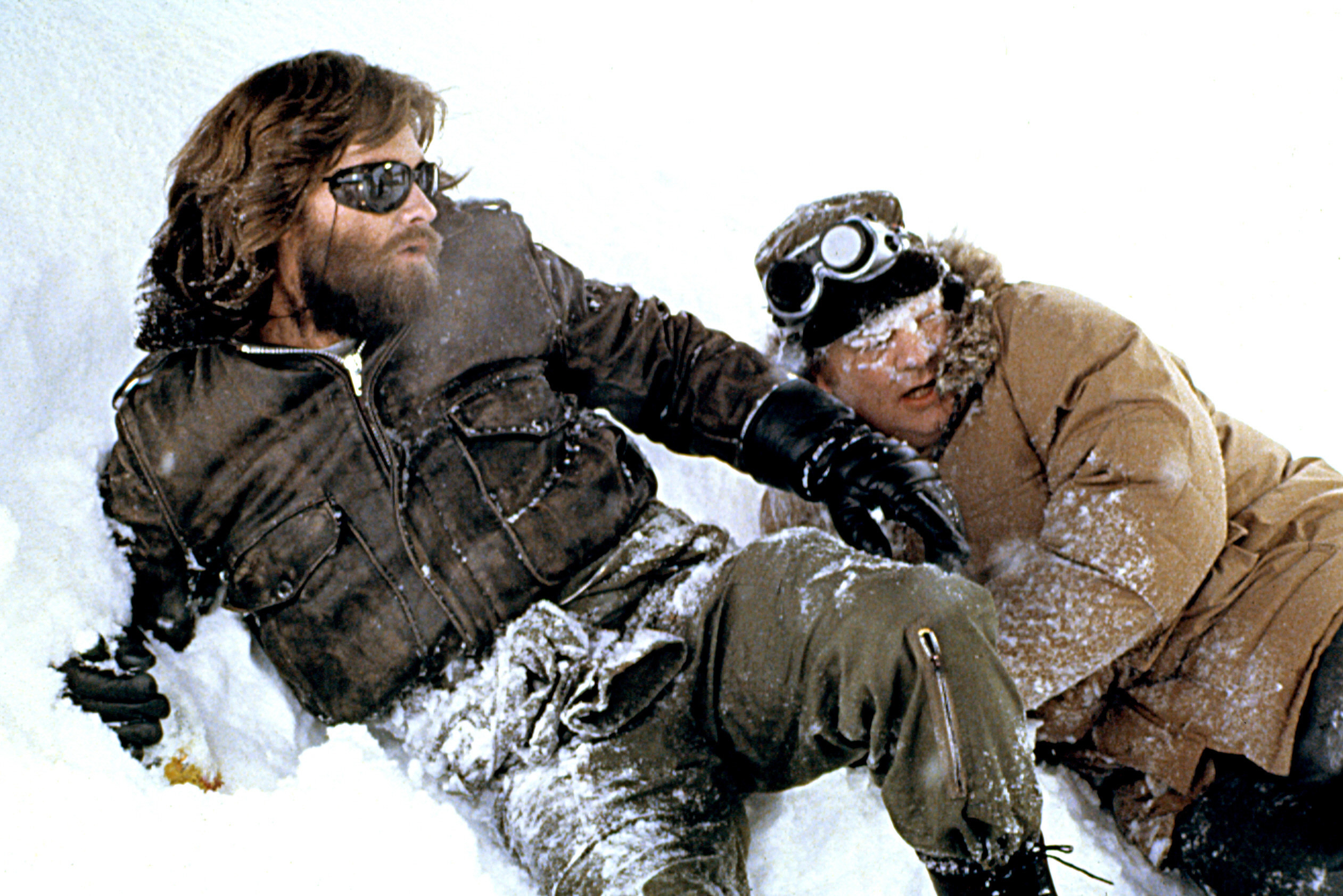 Kurt Russell lying in the snow.