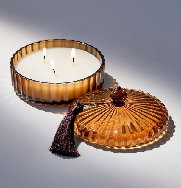 A three-wick candle in a decorative glass jar