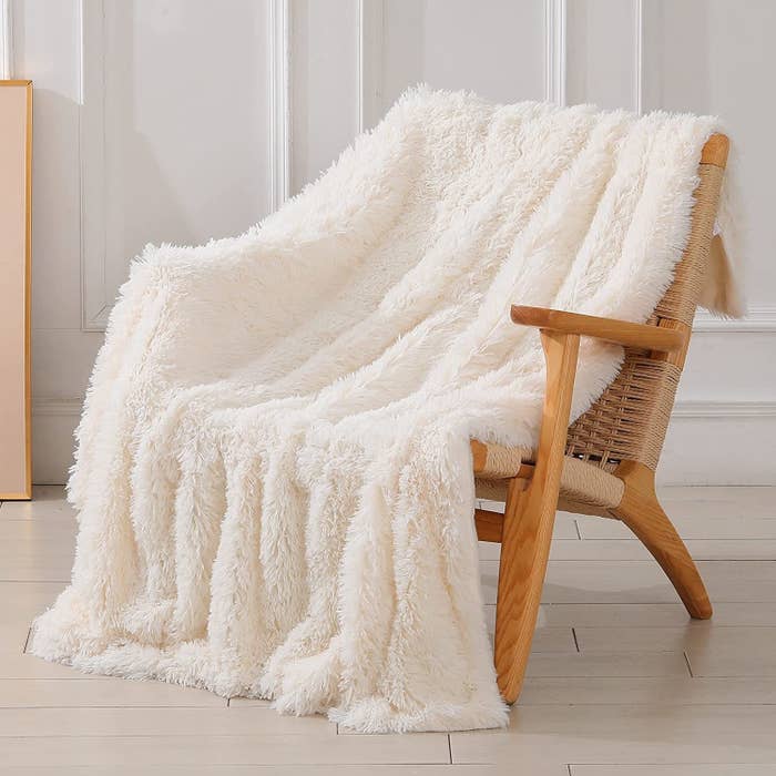 a shaggy blanket draped over a wood chair