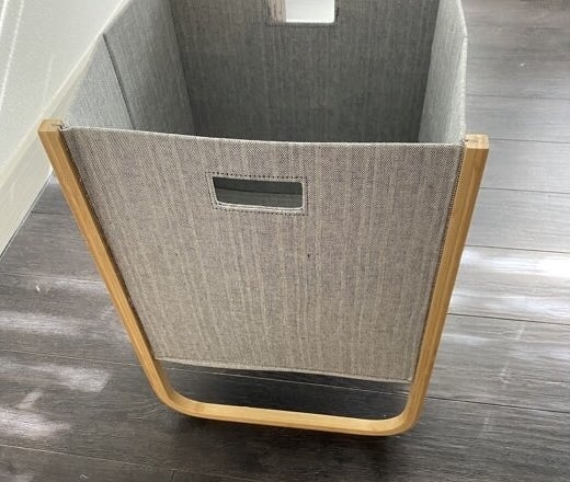 a reviewer photo of the gray and wood hamper