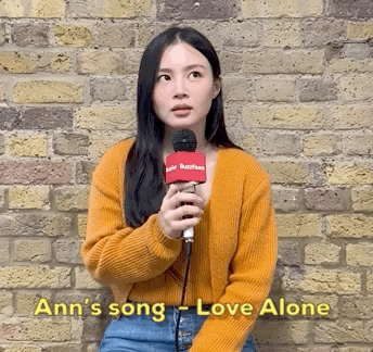 LeeHi sat down against a brick wall, smiling widely and telling us Ann&#x27;s song Love Alone in Korean