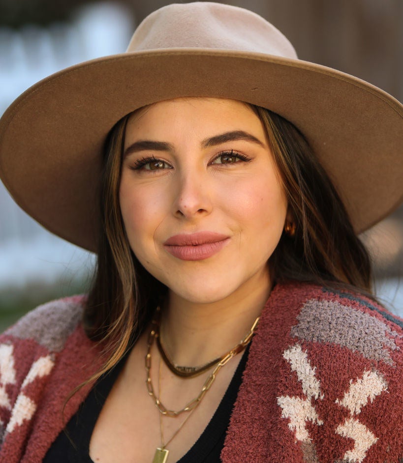 Headshot of Daniella wearing a hat