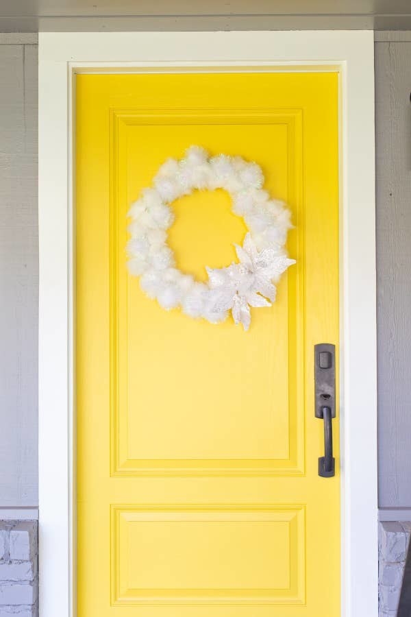 A white wreath hanging on a door