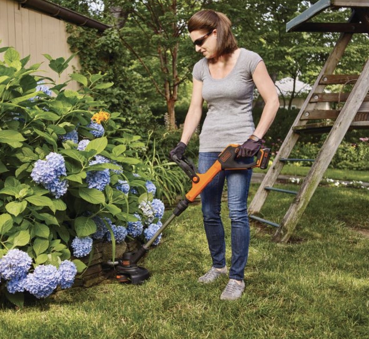 model using the weed whacker in a garden