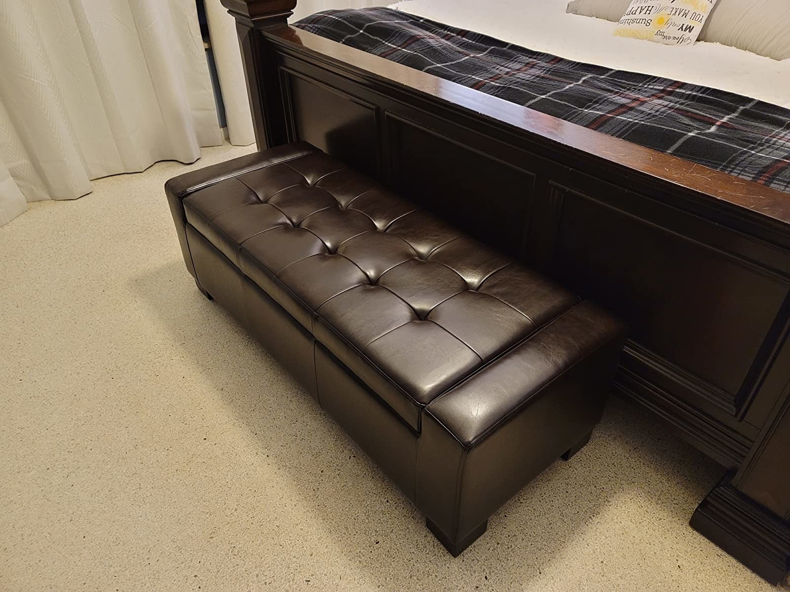 reviewer image of the brown storage ottoman at the foot of a bed