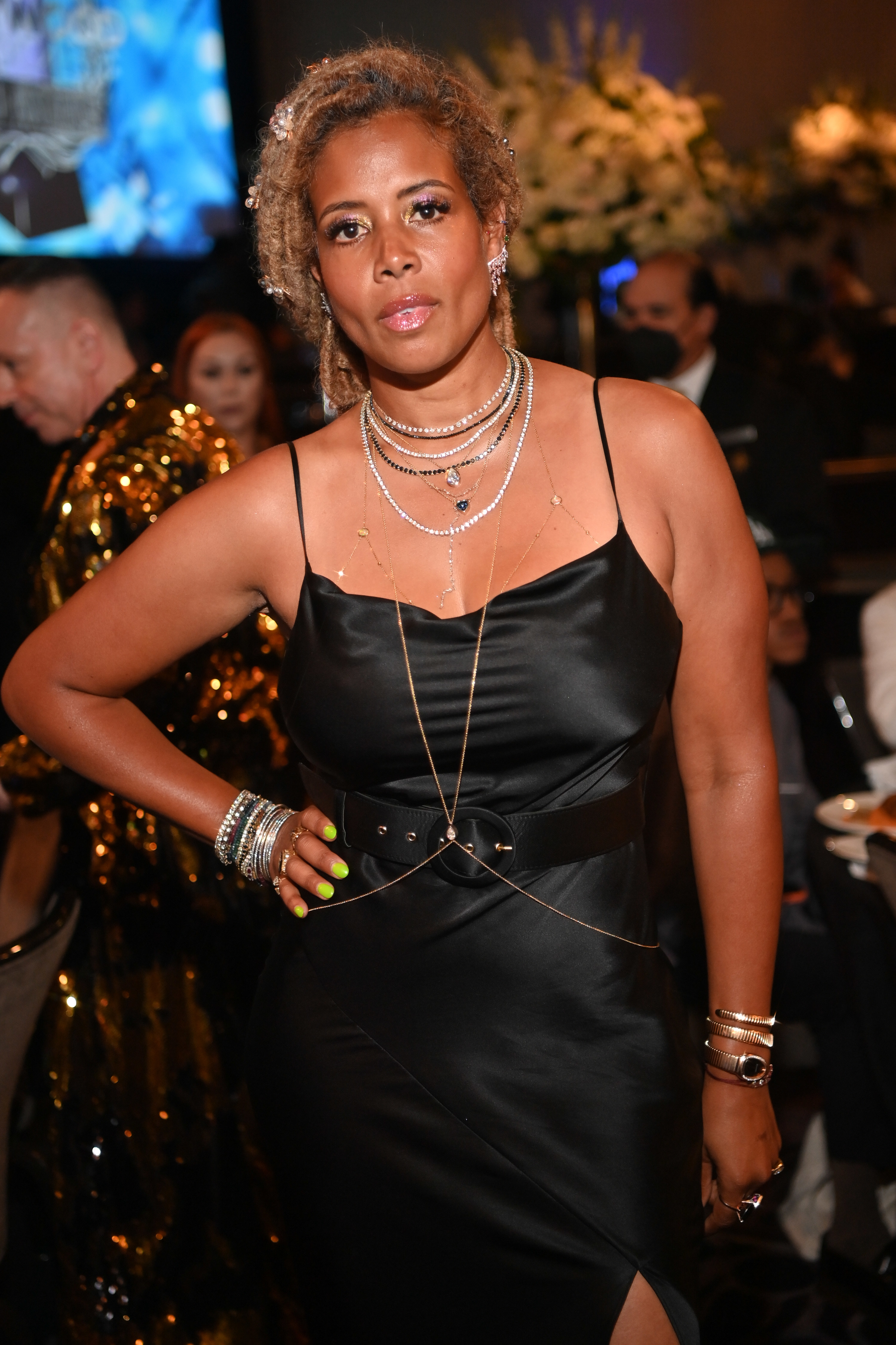 Kelis at an event poses for a photo with her hand on her hip