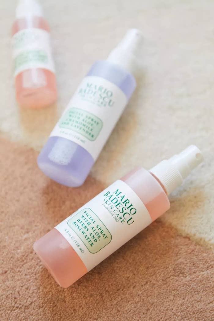 Three bottles of Mario Badescu facial spray on a carpet