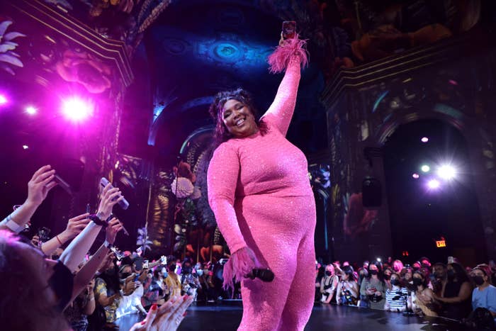 Lizzo performing on stage in a bodysuit