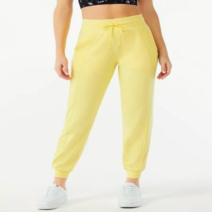 Model wearing yellow joggers and white sneakers