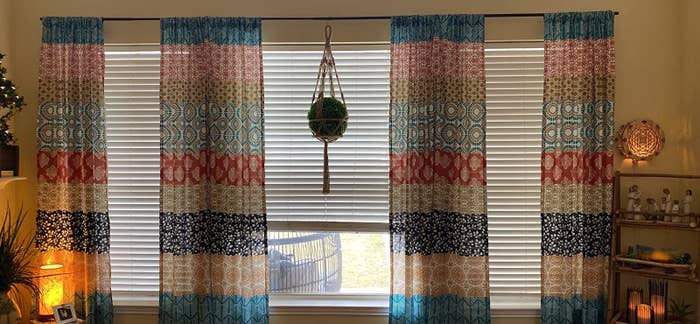 reviewer image of two pairs of the quilt-inspired curtains hanging over windows