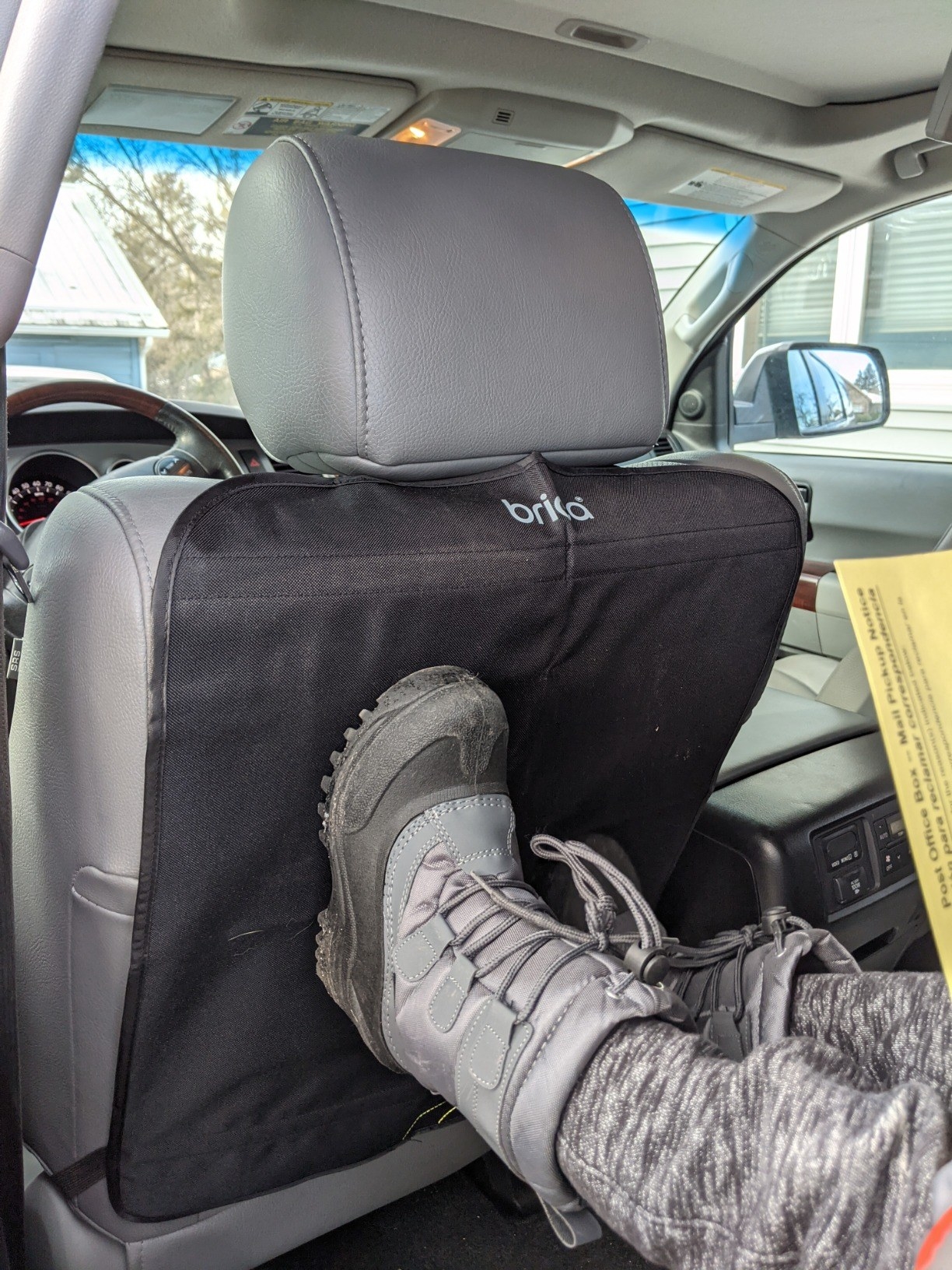 reviewer&#x27;s photo of kid&#x27;s boots on car seat cover