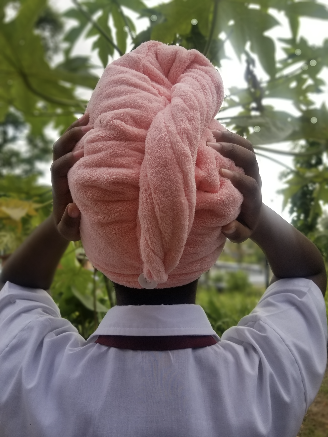 a reviewer showing the pink towel on their head from the back