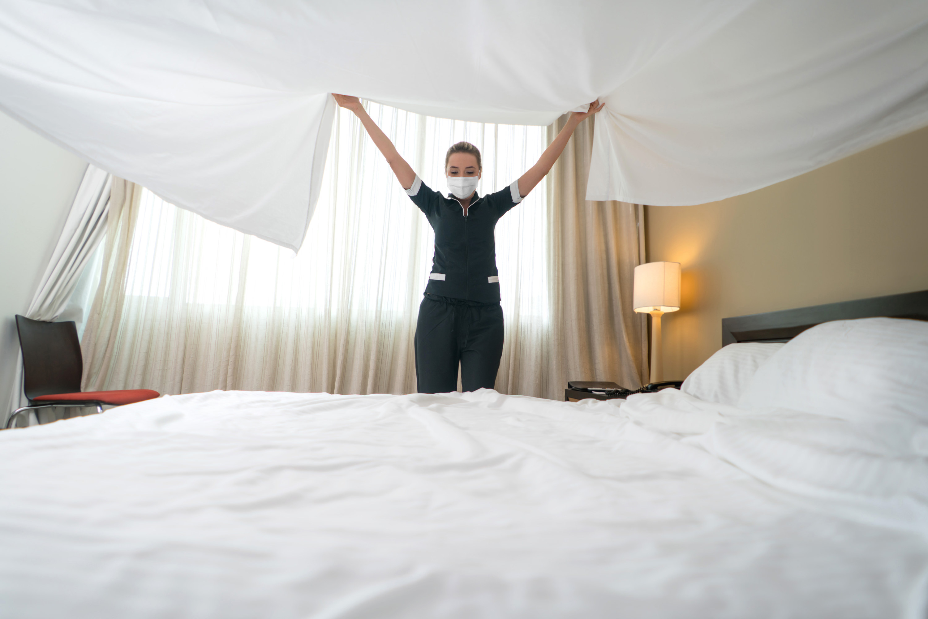 maid making the bed in a hotel