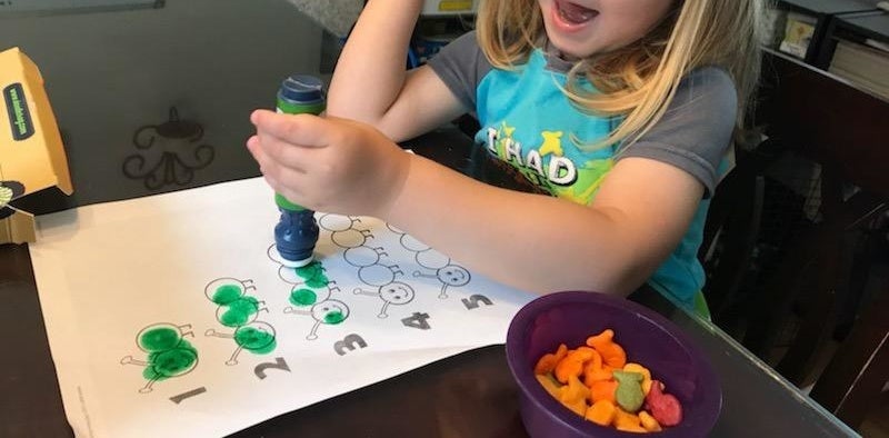 reviewer&#x27;s photo of their child using the dot marker