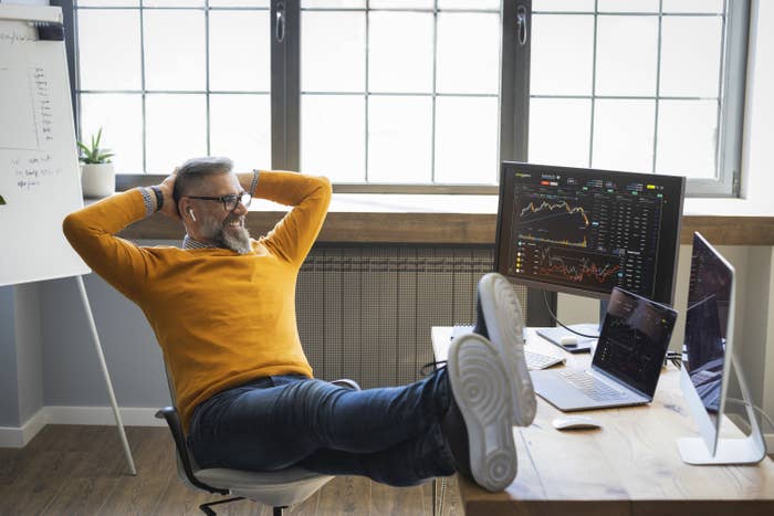 Mature businessman sitting at the table and working on computers