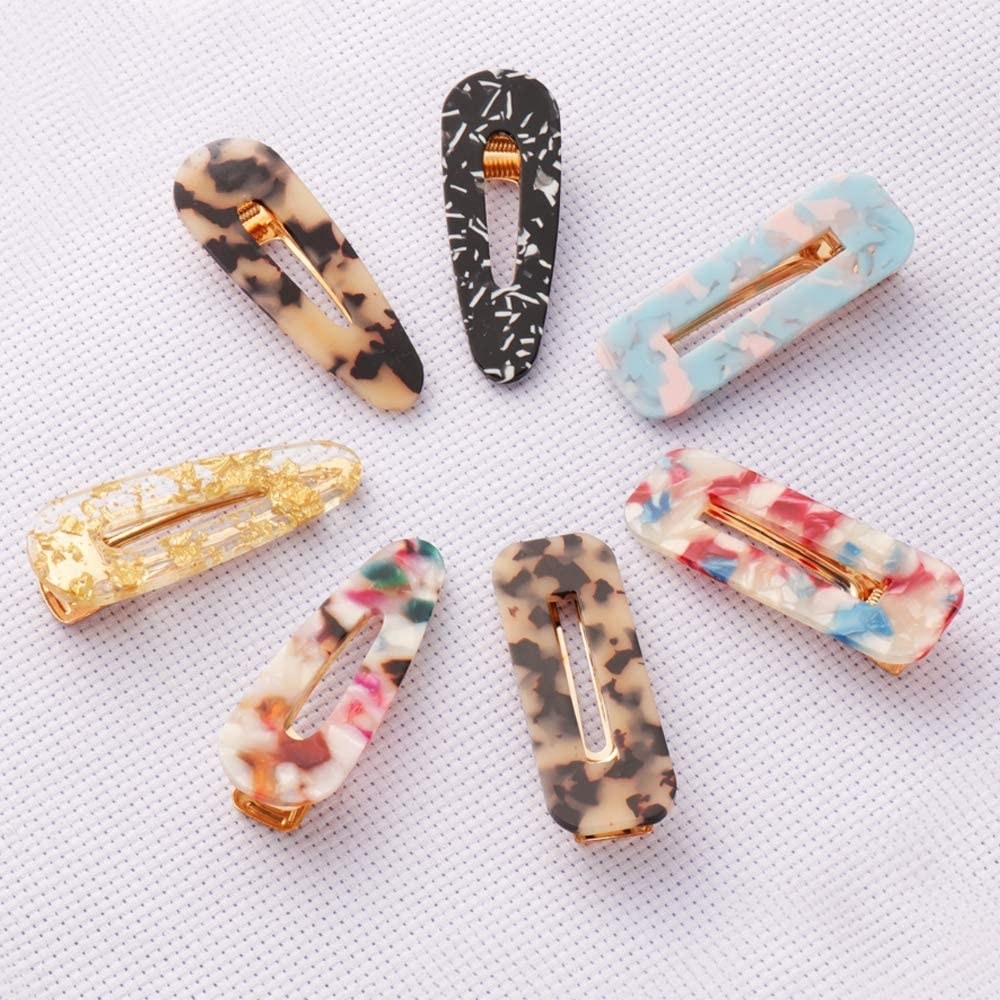 seven patterned hair clips laid out in a circle