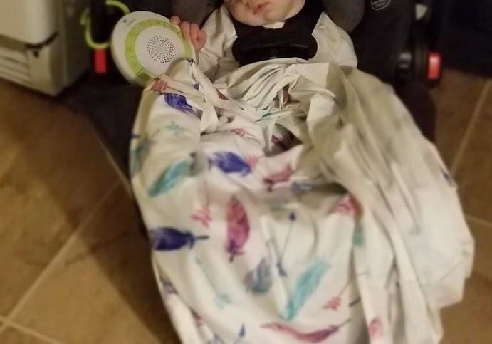 reviewer&#x27;s photo of baby sleeping with portable noise machine