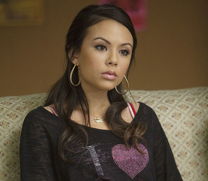 Janel Parrish, who has brown hair and brown eyes