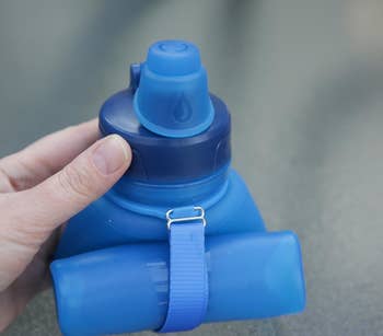 The blue water bottle rolled up in a reviewer's hand
