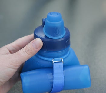 The blue water bottle rolled up in a reviewer's hand