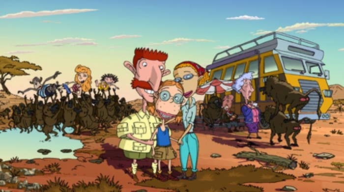 A still from the cartoon The Wild Thornberries showing Eliza with her parents, standing in front of a yellow van, her siblings and lots of monkeys are in the background