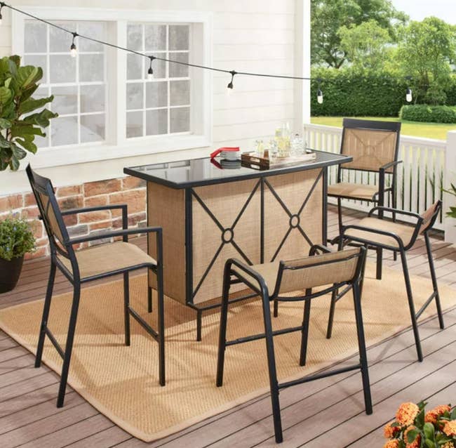 large outdoor bar table with stools and chairs