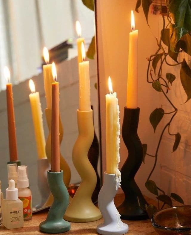 several taper candles in zig-zag holders on a vanity