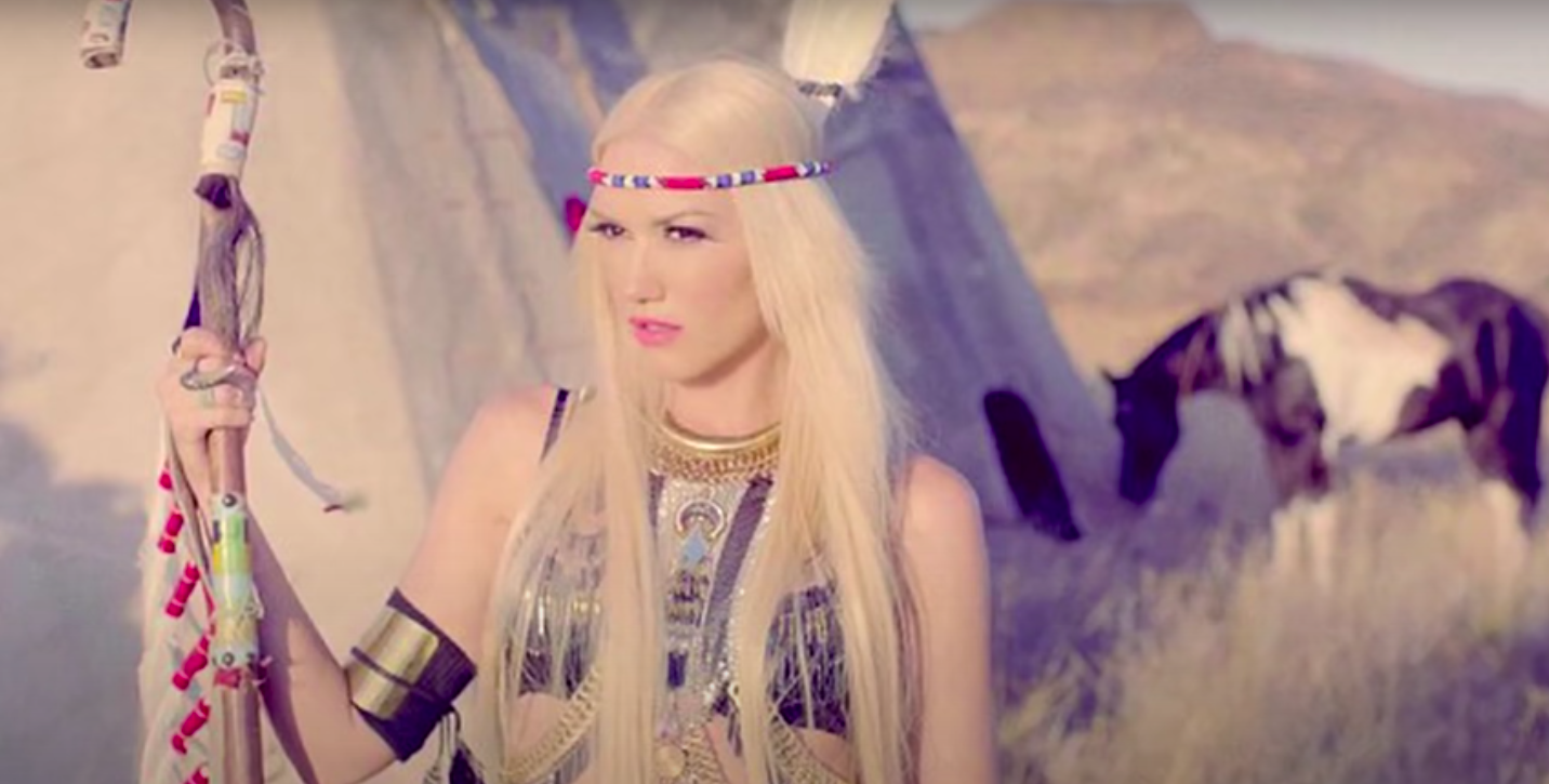 Gwen wearing a headdress and Native American garb in a music video