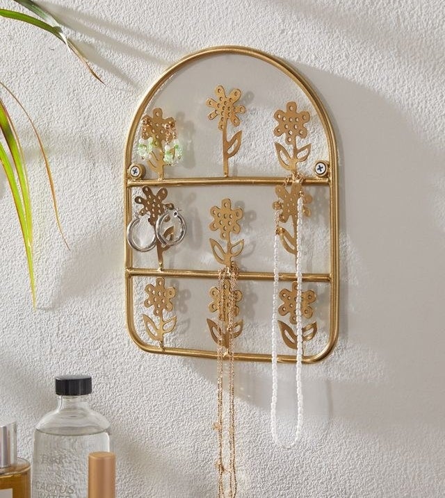 a floral jewellery display with earrings and necklaces hanging off of it