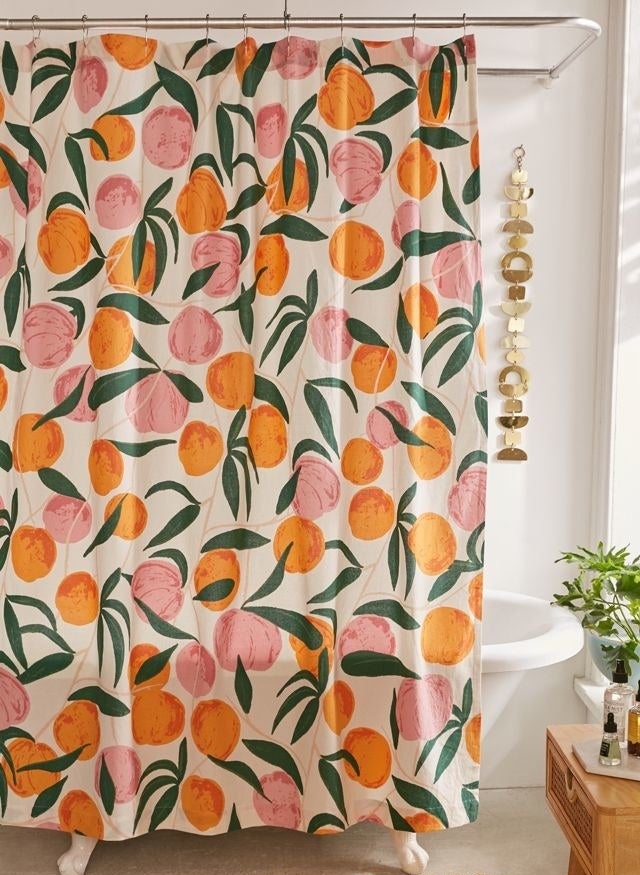 a peach-patterned shower curtain hanging over a tub