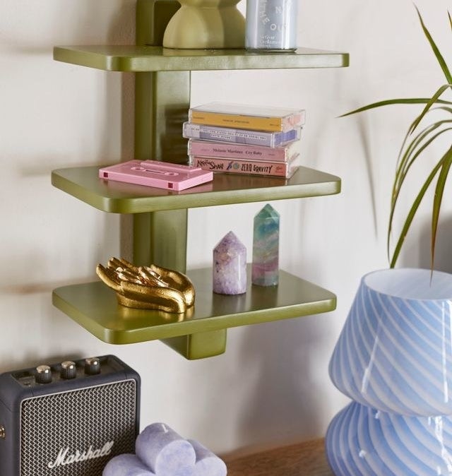 a three-tiered wall shelf with decorative items on each tier