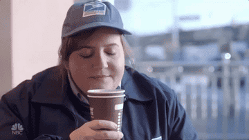 Aidy Bryant drinking Dunkin coffee in an SNL sketch