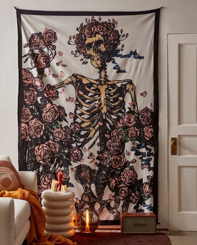 a rose covered skeleton wall tapestry on a wall in a living room