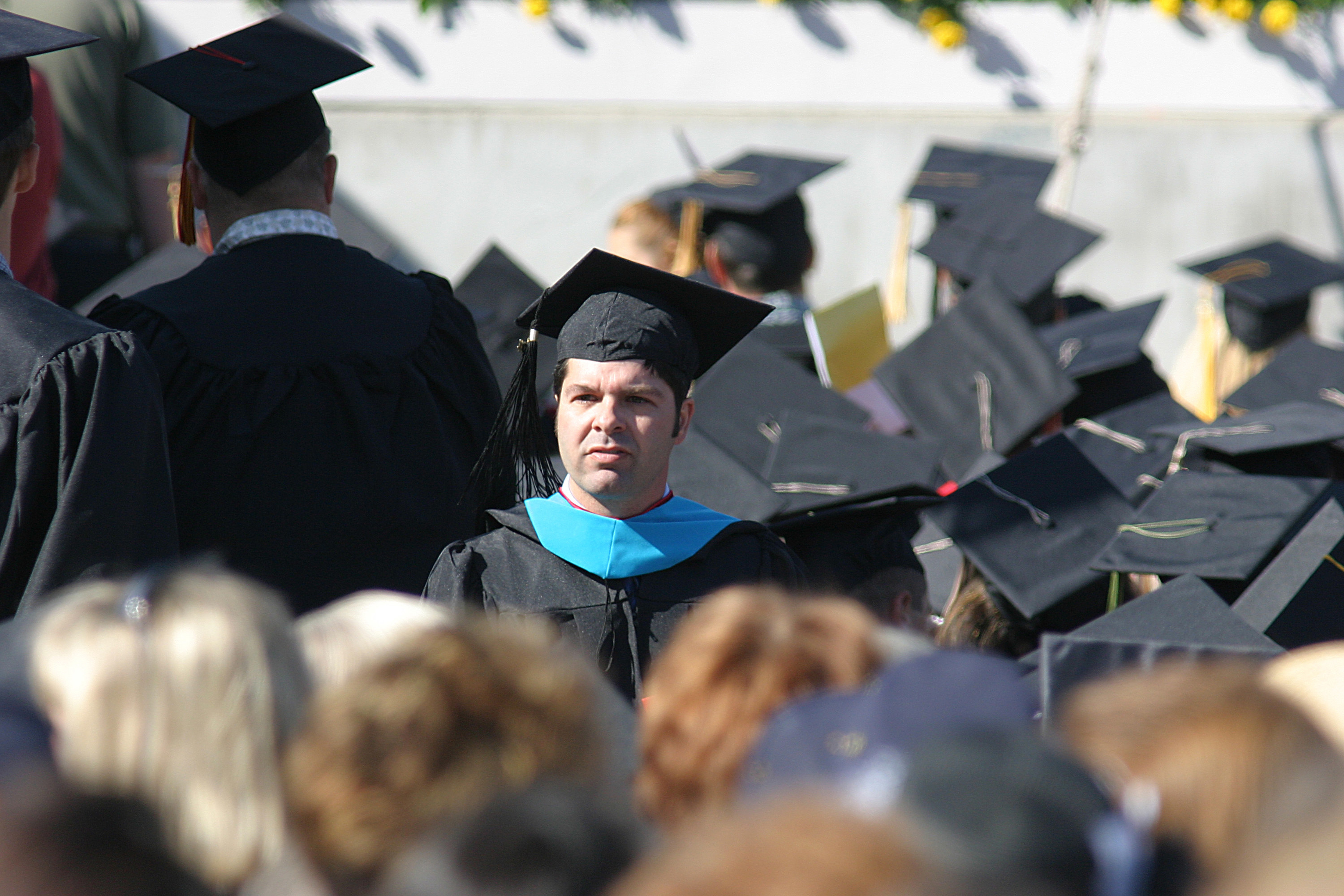 A college graduate stands during commencement
