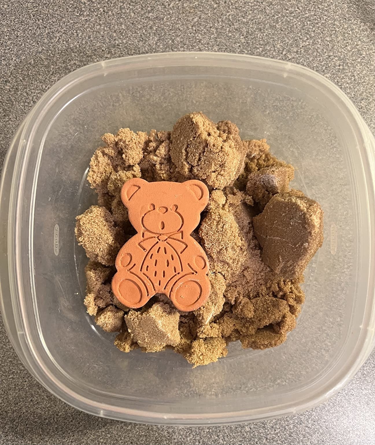 The clay bear in a container of brown sugar