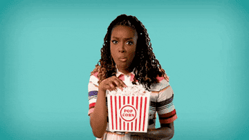 A young woman shaking her head while eating popcorn