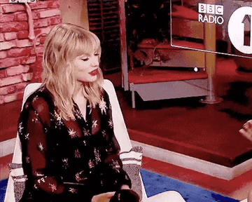 Taylor Swift making a chefs kiss gesture on a BBC Radio interview