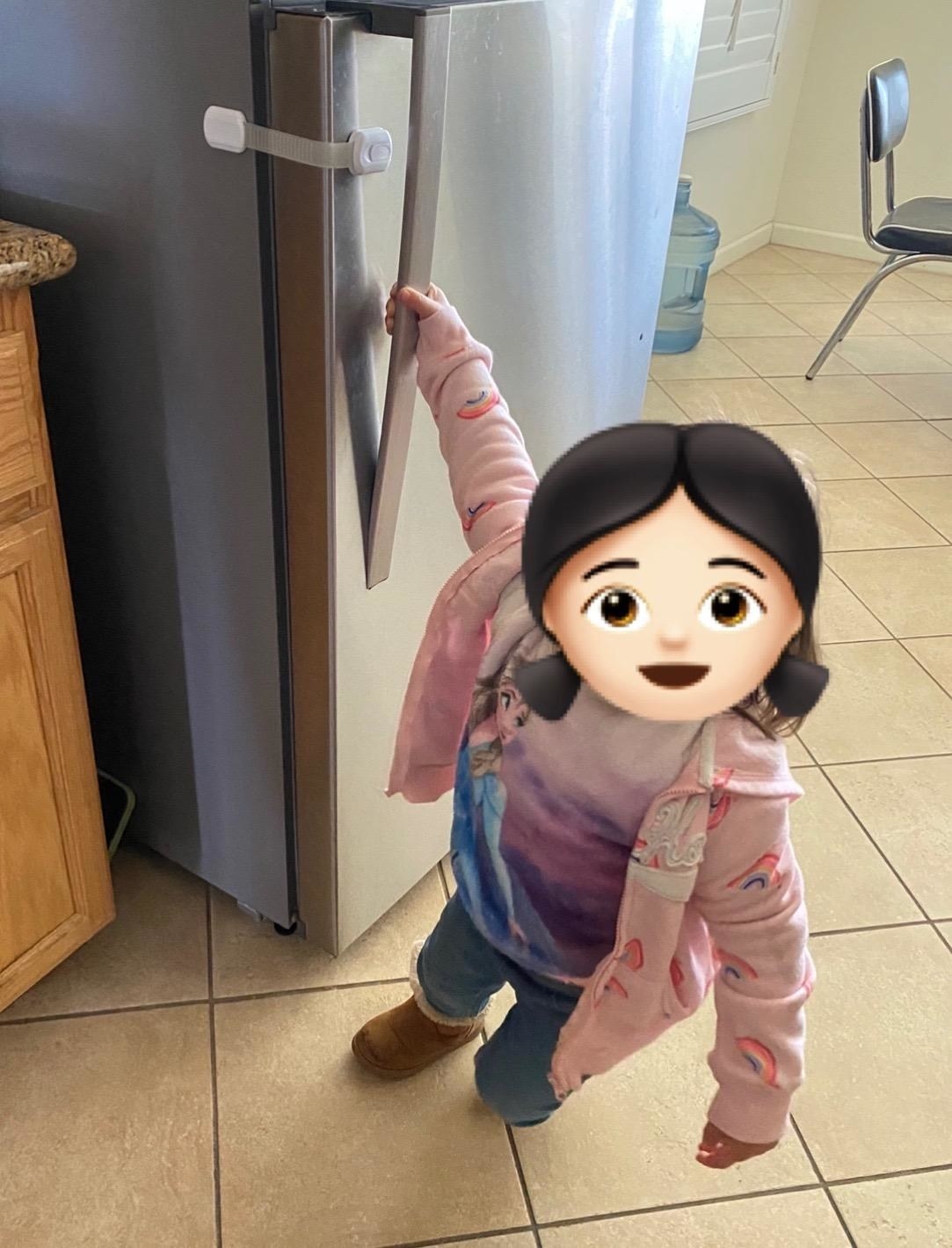 reviewer&#x27;s photo of toddler trying to open fridge