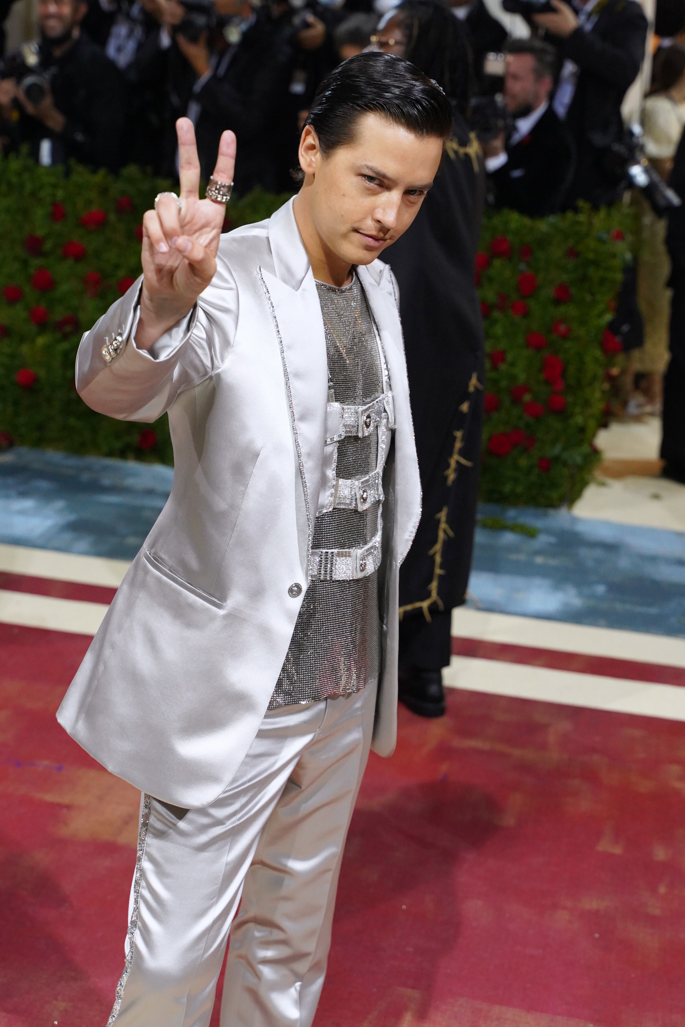 cole giving the peace sign on the red carpet