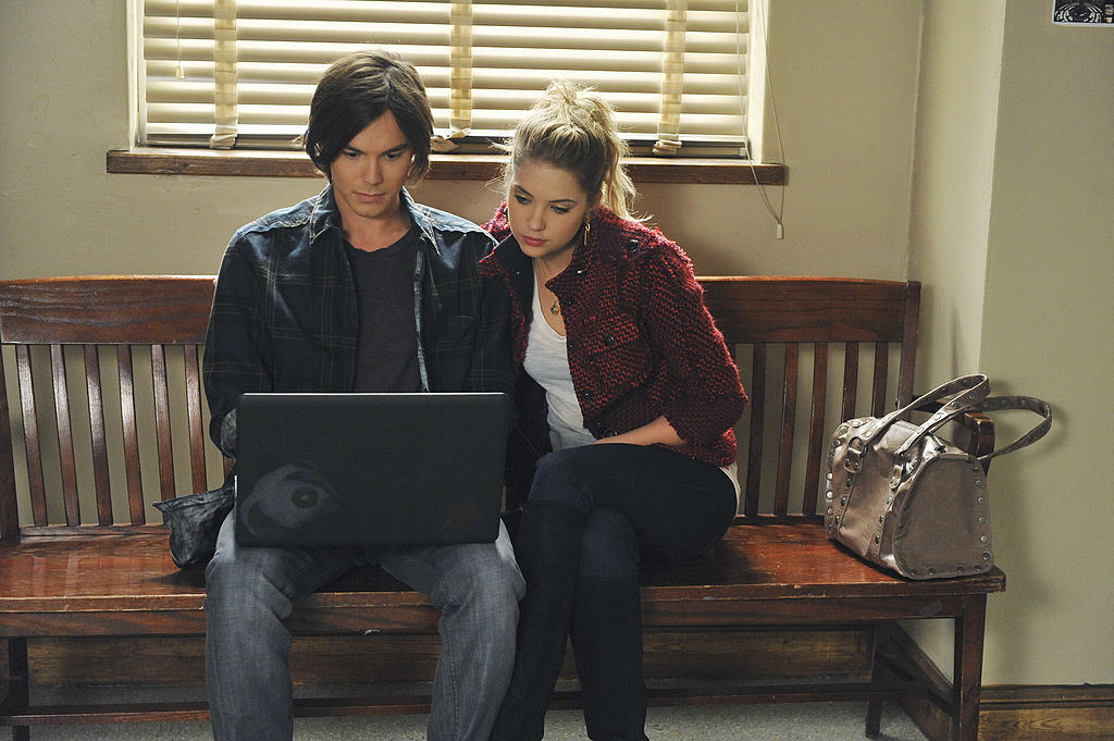 Caleb and Hanna sitting on a bench and looking at a laptop