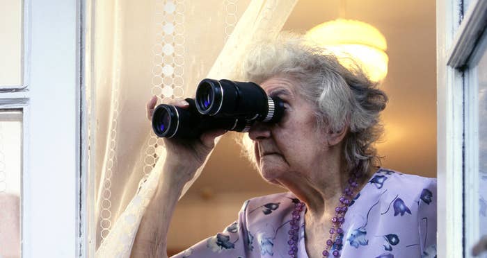An elderly woman looking through binoculars