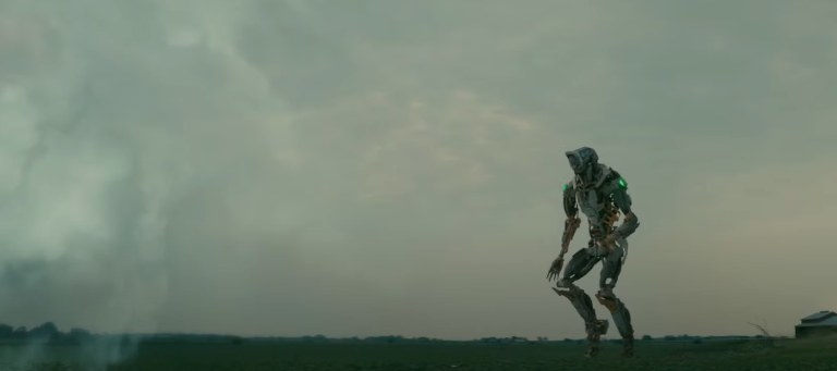 A giant robot runs through a field