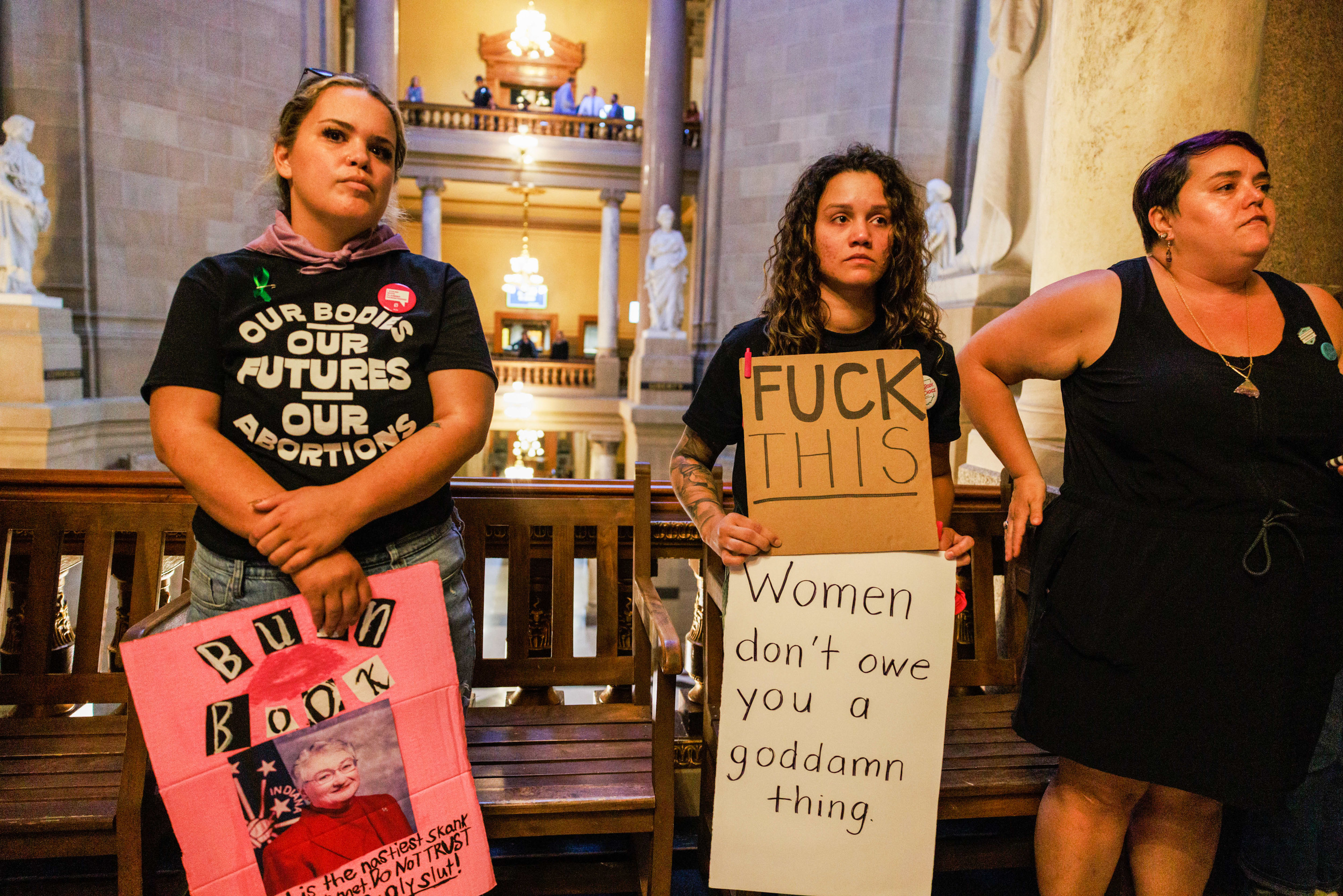 An abortion rights activist holds a sign reading, &quot;Women don&#x27;t owe you a goddamn thing&quot;