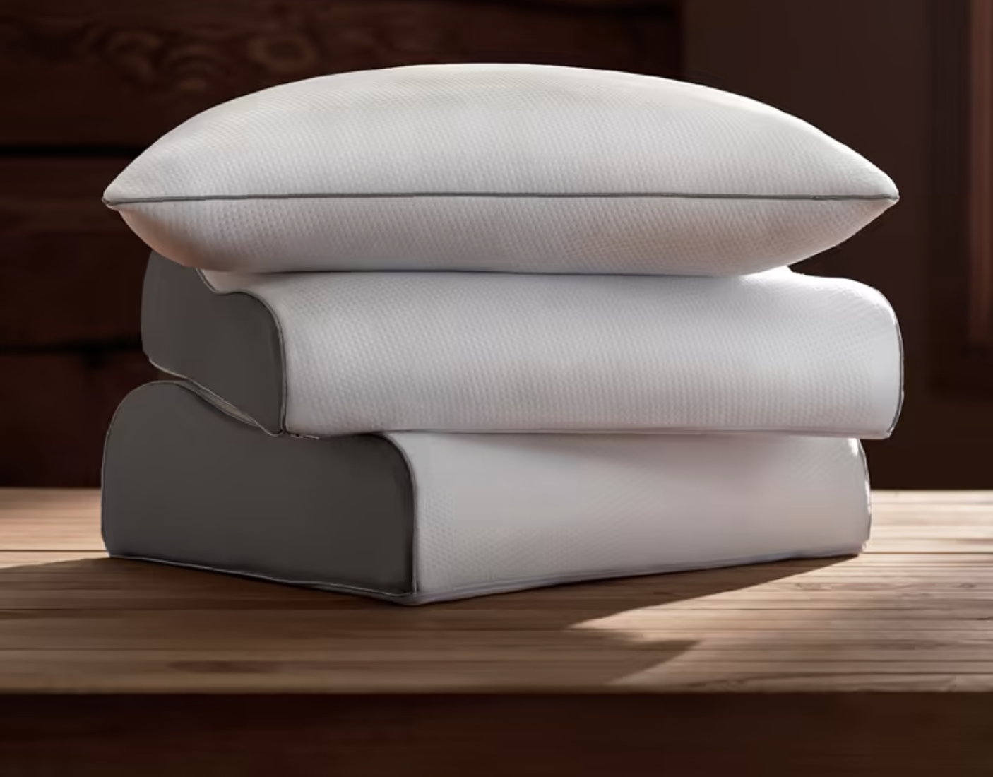 A stack of three different bed pillows are shown