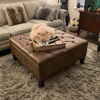 reviewer photo of brown faux leather large square ottoman on four legs
