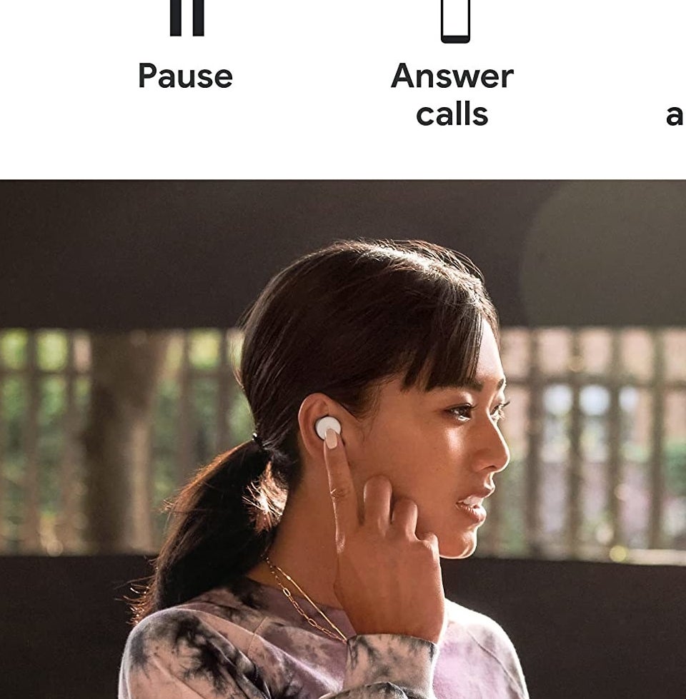 A person pressing the earbud in their ear