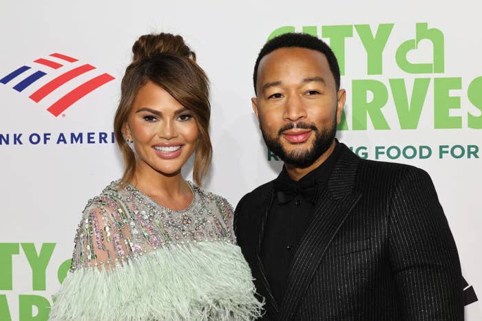 Chrissy and john smiling for pictures on the red carpet