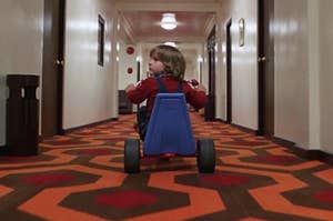 danny torrance rides tricycle through hallway in hotel in the shining movie